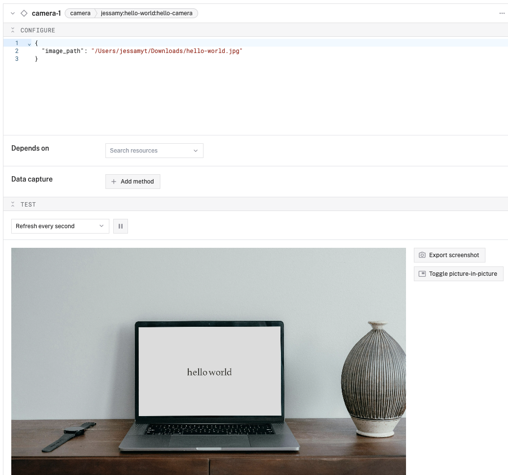 The configuration interface with the Test section of the camera card open, showing a hello world image.